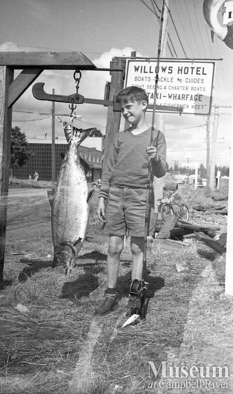 Unidentified child with a salmon at the Willows Hotel